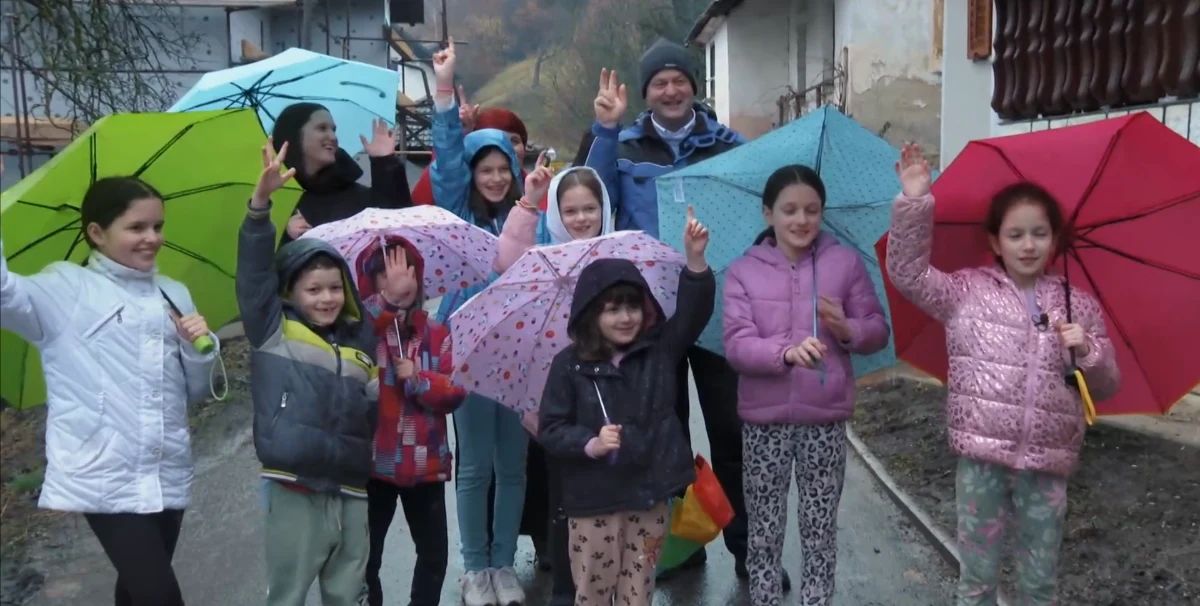 Velika družina iz Delovne akcije skupaj pred prenovo doma - Voyo/posnetek zaslona