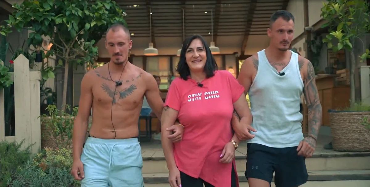 Jan, Žan in njuna mama skupaj stojijo nasmejani med obiskom družine - Voyo/posnetek zaslona